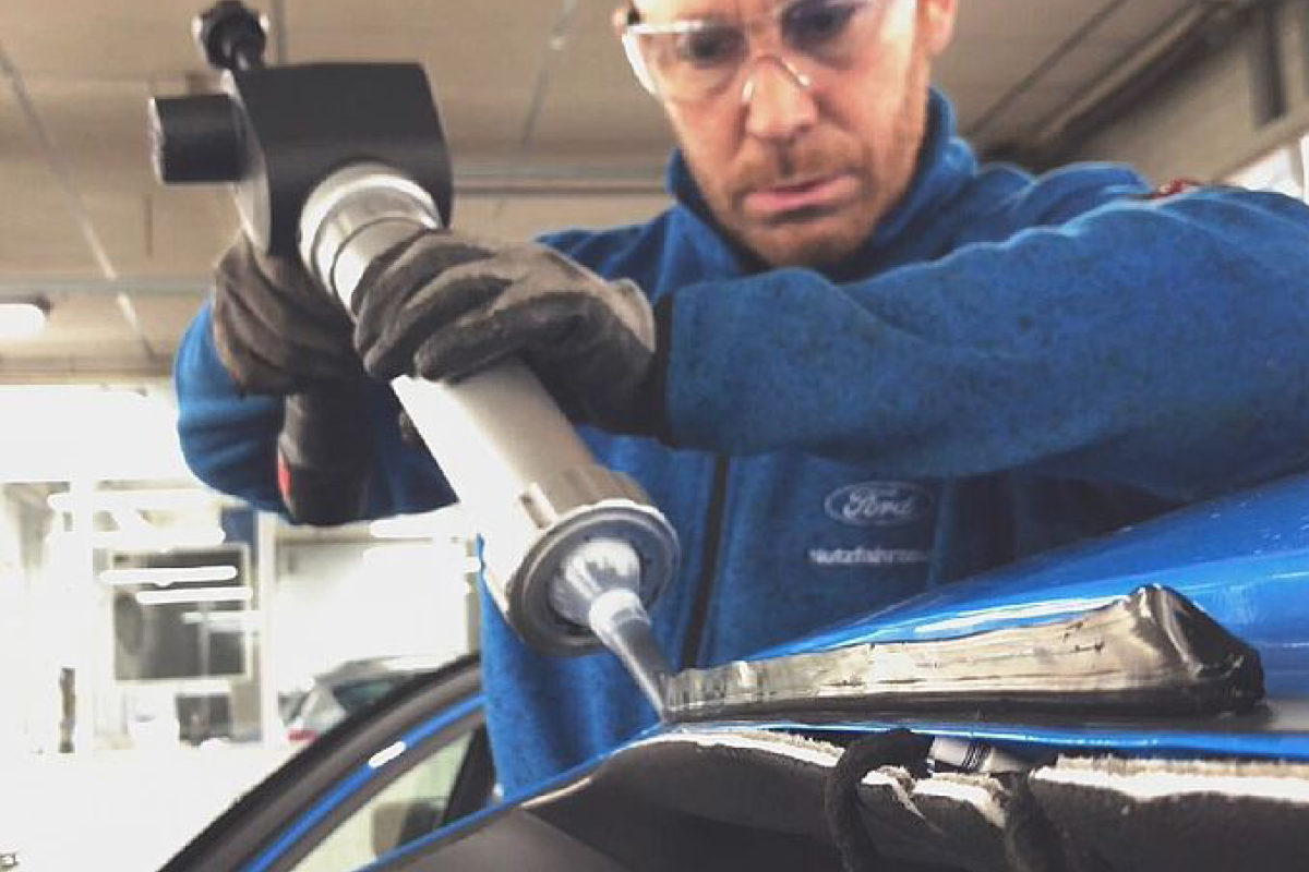 Eine Person führt eine Montage der Windschutzscheibe durch