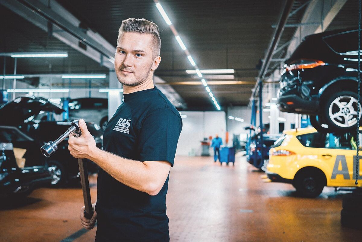 Zu sehen ist ein Mitarbeiter mit einem Werkzeug in der Hand